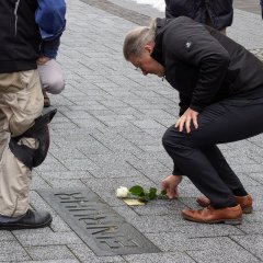 Bürgermeister Bernd Goffart legt Rosen an den Steinen nieder