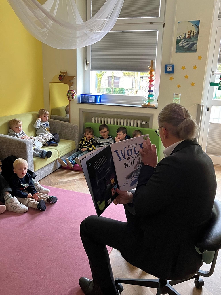 Bürgermeister Bernd Goffart zeigt mehreren Kindern ein offenes Buch