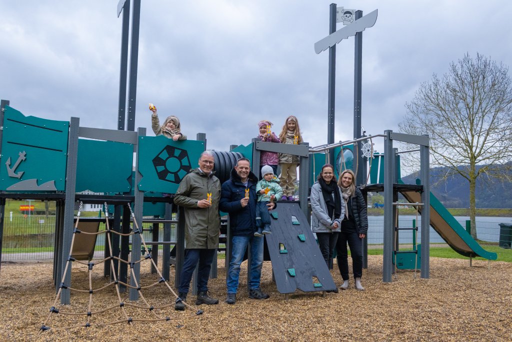 Bürgermeister Bernd Goffart und Ortsvorsteher Sander Lutterbach zusammen mit Kindern und Müttern am Spielschiff