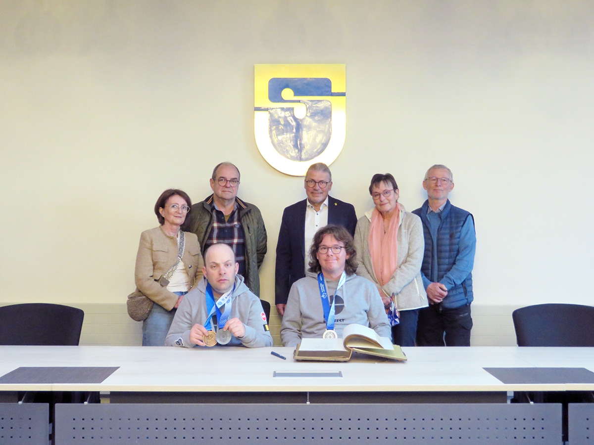 Markus Knein (v. l., Eltern im Hintergrund) und Hendrik Ritter (v. r., Eltern im Hintergrund) haben sich auf Einladung von Bürgermeister Bernd Goffart in das Goldene Buch das Gemeinde Simmerath eingetragen.