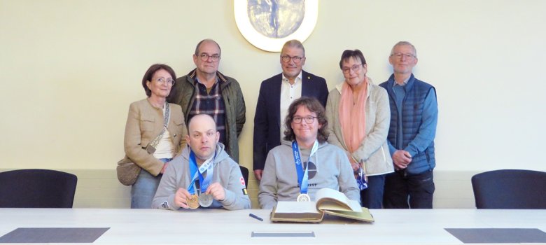 Markus Knein (v. l., Eltern im Hintergrund) und Hendrik Ritter (v. r., Eltern im Hintergrund) haben sich auf Einladung von Bürgermeister Bernd Goffart in das Goldene Buch das Gemeinde Simmerath eingetragen.