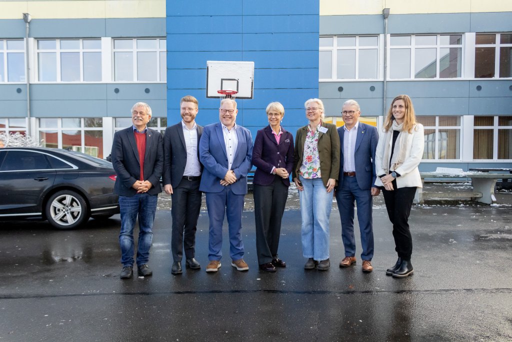 Gruppenfoto vor dem Schulgebäude mit v. l. n. r.: Klaus Onasch (Roetgen), Daniel Scheen-Pauls MdL, Stephan Cranen (Hürtgenwald), Ministerin Dorothee Feller, Schulleiterin Diana Hoch, Bernd Goffart (Simmerath), Dr. Carmen Krämer (Monschau)