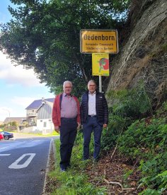Bürgermeister Bernd Goffart und Helmut Kaulard vor dem Ortsschild in Dedenborn