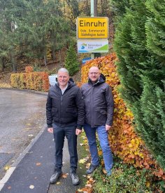 Bürgermeister Bernd Goffart und Ortsvorsteher Christoph Poschen vor dem Ortsschild von Einruhr