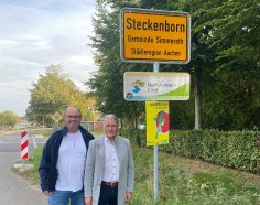 Ralph Löhr und Bernd Goffart vor dem Ortsschild "Steckenborn"