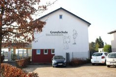 Ansicht auf das Gebäude der Grundschule Steckenborn, auf dem groß das Logo der Schule mit Schriftzug sichtbar ist