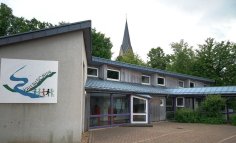 Ansicht der Kalltalschule mit Logo auf dem Gebäude im Vordergrund