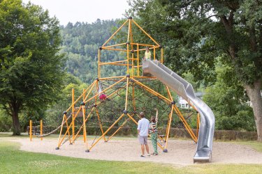 Familie auf einem Spielplatz an einem großen Klettergerüst