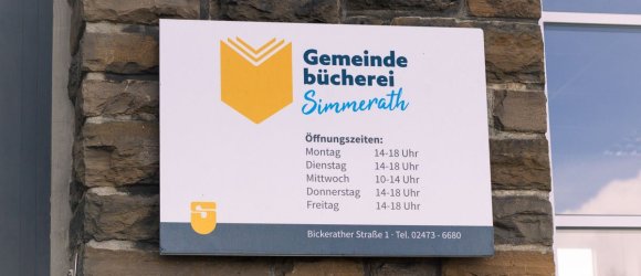 Schild mit dem Öffnungszeiten am Eingang der Gemeindebücherei